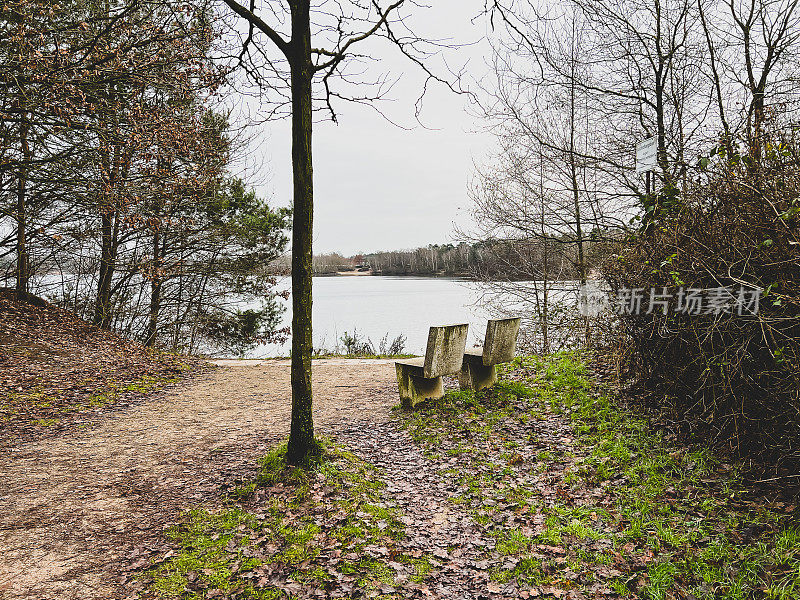 在冬天，两根石凳挨着一棵树，俯瞰着名为“Offlumer See”的湖。